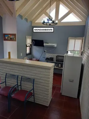 a restaurant with two chairs and a counter with a refrigerator at Complejo Calas in Merlo