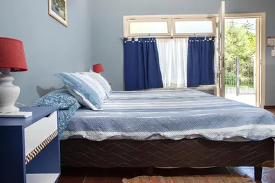 a bedroom with a bed with blue sheets and a window at Complejo Calas in Merlo