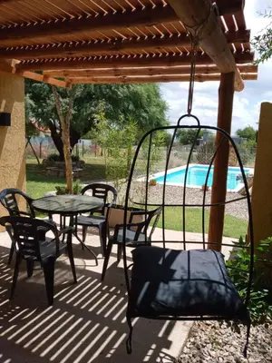 a patio with a table and chairs and a pool at El Rincón de Alejo in Merlo