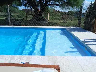 a swimming pool with blue water in a yard at El Rincón de Alejo in Merlo
