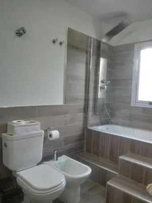 a bathroom with a toilet and a sink and a tub at El Rincón de Alejo in Merlo