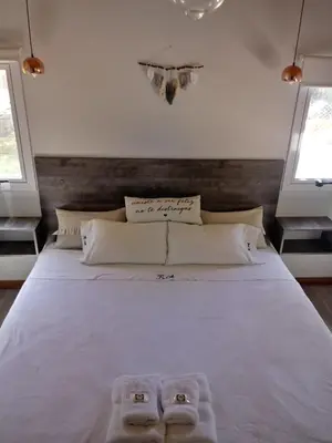 a large white bed with two towels on it at El Rincón de Alejo in Merlo