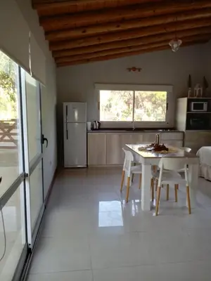 a kitchen with a white table and a refrigerator at El Rincón de Alejo in Merlo