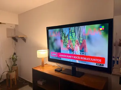 a flat screen tv sitting on top of a wooden table at Departamento 100% equipado y excelente ubicación in Cordoba
