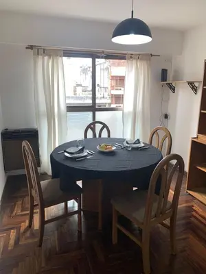 a dining room table and chairs with a blue table and a window at Departamento 100% equipado y excelente ubicación in Cordoba