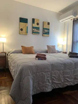 a bedroom with two beds and two paintings on the wall at Departamento 100% equipado y excelente ubicación in Cordoba