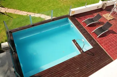 an overhead view of a swimming pool with two chairs at Hostal de la Costa in Villa Carlos Paz