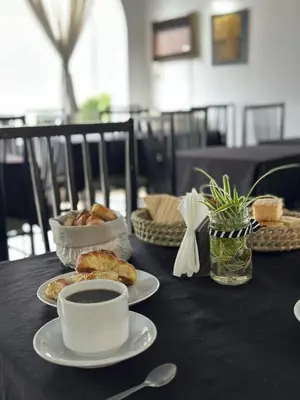 a table with a cup of coffee and pastries on it at Hostal de la Costa in Villa Carlos Paz