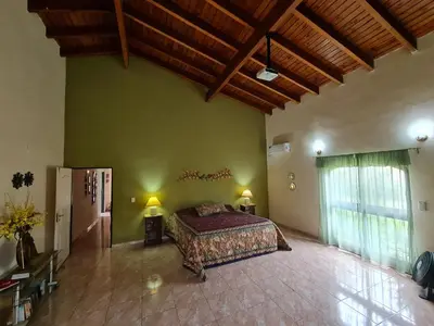 a bedroom with a bed and a green wall at HERMOSA CASA con 4000mts de PARQUE en las SIERRAS DE CORDOBA in José de la Quintana