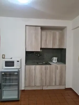 a kitchen with wooden cabinets and a microwave at Hermoso Monoambiente en Nva Cordoba in Cordoba