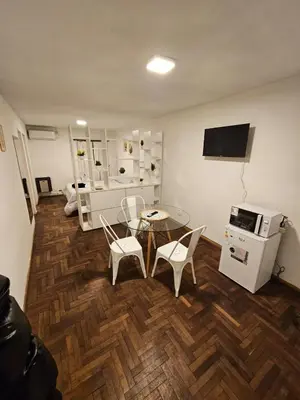 a living room with a table and chairs and a microwave at Monoambiente Centro in Cordoba