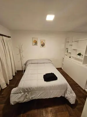 a white bedroom with a large bed in it at Monoambiente Centro in Cordoba