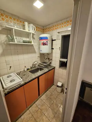 a small kitchen with a sink and a water heater at Monoambiente Centro in Cordoba