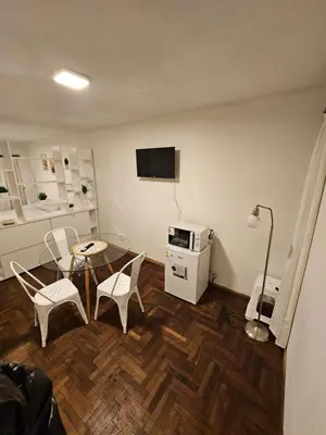 a living room with a table and chairs and a television at Monoambiente Centro in Cordoba