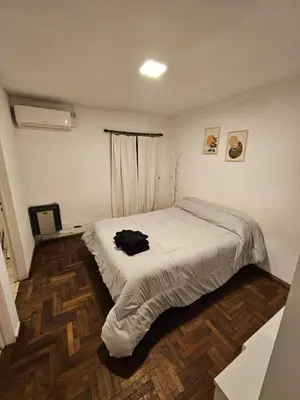 a bedroom with a bed with a black shirt on it at Monoambiente Centro in Cordoba