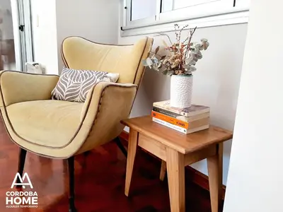 a living room with a chair and a table with a vase at A&A Cordoba Home - Duplex Boutique en Nueva Cordoba in Cordoba
