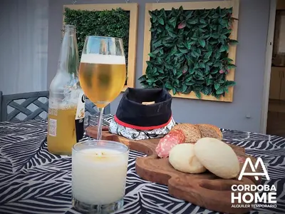 a table with a glass of beer and bread and a candle at A&A Cordoba Home - Duplex Boutique en Nueva Cordoba in Cordoba