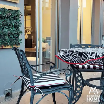 a table and two chairs on a porch with a table and a window at A&A Cordoba Home - Duplex Boutique en Nueva Cordoba in Cordoba