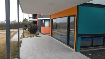 an external view of a building with a walkway at Complejo Cuatro Colores - Apart Hotel in Potrero de Garay