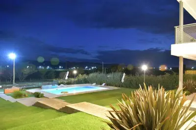 a backyard with a swimming pool at night at Complejo Cuatro Colores - Apart Hotel in Potrero de Garay