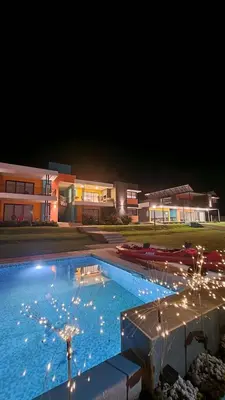 a large swimming pool with lights in front of a building at Complejo Cuatro Colores - Apart Hotel in Potrero de Garay