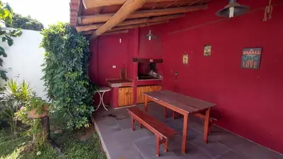 a red building with a wooden table and a bench at DEPARTAMENTO DIARIO PASEO DEL JOCKEY in Cordoba