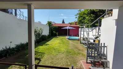 a view of the yard of a house with an umbrella at DEPARTAMENTO DIARIO PASEO DEL JOCKEY in Cordoba