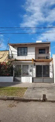 a large white house with a balcony on a street at DEPARTAMENTO DIARIO PASEO DEL JOCKEY in Cordoba
