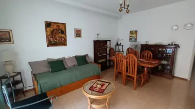 a living room with a green couch and a table at DEPARTAMENTO DIARIO PASEO DEL JOCKEY in Cordoba