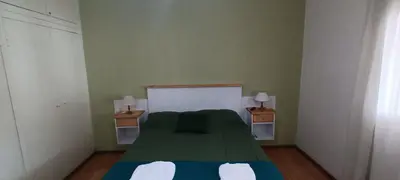 a bedroom with a green bed with two night stands at DEPARTAMENTO DIARIO PASEO DEL JOCKEY in Cordoba