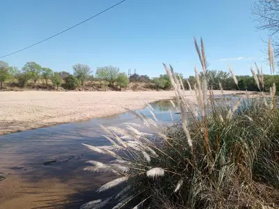 a patch of grass next to a body of water at Luz de las Sierras 2 in Arroyo de Los Patos