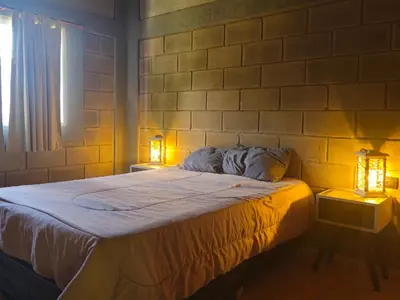a bedroom with a bed with two lights on it at CABAÑA DORADA in Villa Ciudad de America