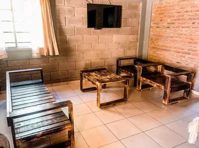 a room with three wooden benches and a tv at CABAÑA DORADA in Villa Ciudad de America