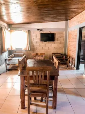 a room with a table and chairs and a tv at CABAÑA DORADA in Villa Ciudad de America