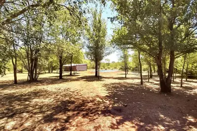 a field with trees and a building in the distance at CABAÑA DORADA in Villa Ciudad de America