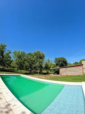 a swimming pool with green water in a yard at CABAÑA DORADA in Villa Ciudad de America