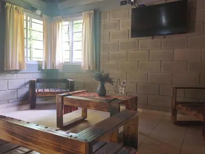 a living room with two tables and a flat screen tv at CABAÑA DORADA in Villa Ciudad de America