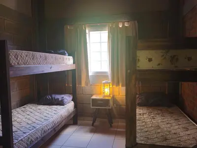 two bunk beds in a room with a window at CABAÑA DORADA in Villa Ciudad de America