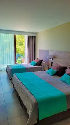 a hotel room with three beds and a large window at Hotel Estilo MB - Merlo in El Rincón