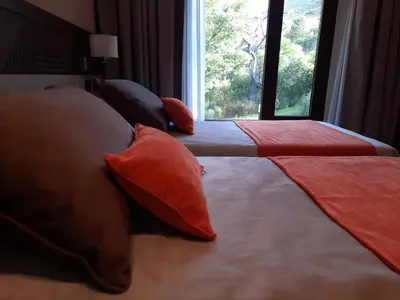 a bedroom with two beds with pillows and a window at Hotel Estilo MB - Merlo in El Rincón