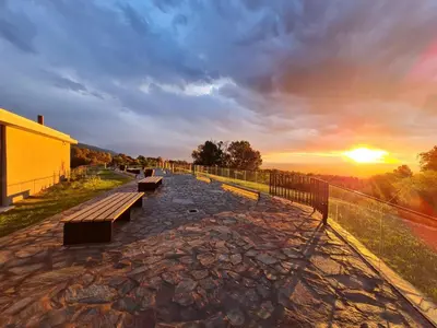 a group of benches sitting on top of a hill at sunset at Hotel Estilo MB - Merlo in El Rincón