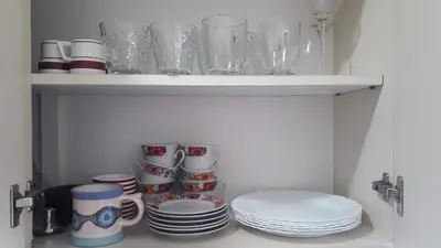 a shelf with plates and cups and glasses on it at Artigas in Cordoba