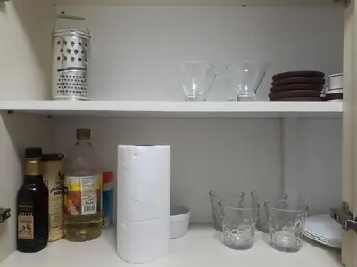a shelf with glasses and a roll of paper towels at Artigas in Cordoba