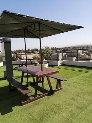 a picnic table with an umbrella on a roof at Punto Urbano in Villa Carlos Paz