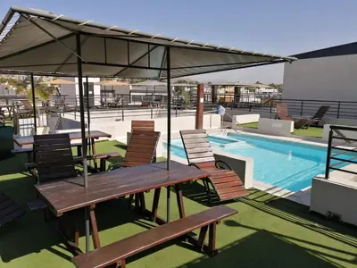 a patio with tables and chairs next to a swimming pool at Punto Urbano in Villa Carlos Paz