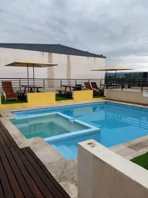 a large swimming pool with chairs and a table at MIRALEJOS33K in Villa Carlos Paz