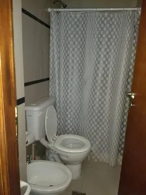 a bathroom with a toilet and a shower curtain at MIRALEJOS33K in Villa Carlos Paz