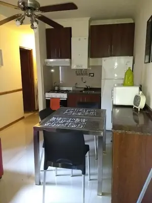 a kitchen with a table with chairs and a refrigerator at MIRALEJOS33K in Villa Carlos Paz