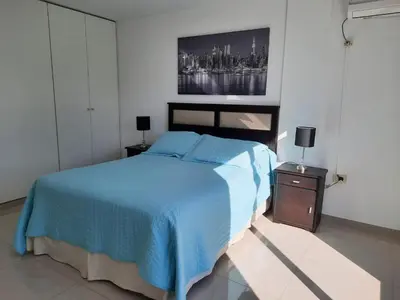 a bedroom with a blue bed and a painting on the wall at Departamento en Nueva Córdoba in Cordoba