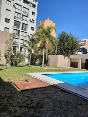 a swimming pool in front of a tall building at Departamento en Nueva Córdoba in Cordoba